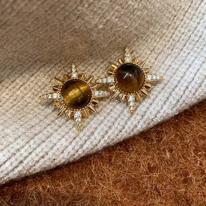 Dettaglio degli orecchini a stella placcati oro 18k con una pietra occhio di tigre