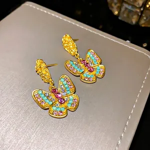 Vintage butterfly stud earrings with colorful rhinestones and gold pleated finish