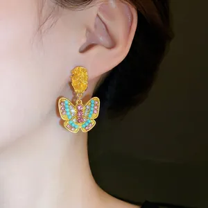 Vintage gold butterfly stud earrings inlaid with colorful rhinestones shown on model