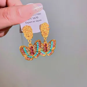 Vintage golden butterfly stud earrings with colorful rhinestones and textured finish