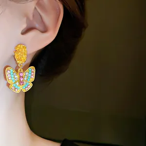 Detailed macro view of vintage butterfly earrings featuring colorful rhinestones on model ear