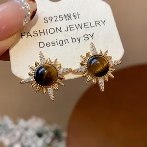 Primo piano di eleganti orecchini occhio di tigre con placcatura in oro 18k e zirconi