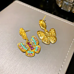 Elegant vintage butterfly earrings with colorful rhinestones on a textured display box