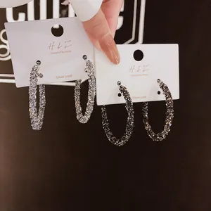 Orecchini a cerchio glitterati con perno in argento per un look molto trendy.