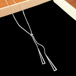 Primer plano del collar en Y ajustable plateado con colgantes triangulares geométricos.