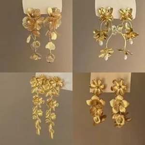 Macro view of four styles of golden floral metal tassel earrings with S925 silver needles