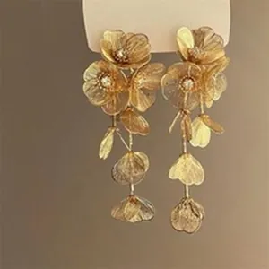 Detailed view of gold wrinkled floral dangle earrings with delicate metal petals.