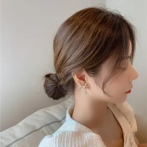Elegant silver needle bow pearl earrings with crystals worn by model in profile view