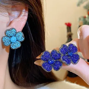 Vintage style flower stud earrings with pave blue rhinestones and silver needles