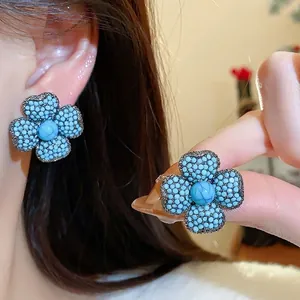 Vintage four-petal flower earrings with blue beaded texture and turquoise center stone