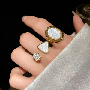 Nahaufnahme eines goldenen Rings mit Perlmutt- und Zirkonia-Details im Vintage-Stil