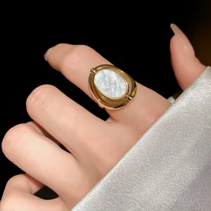 Nahaufnahme eines verstellbaren goldenen Vintage-Rings mit Perlmutt-Inlay am Finger