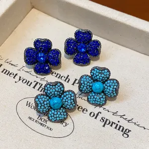 Vintage style four-leaf clover stud earrings with blue crystals and turquoise details.