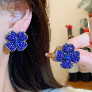 Close-up of elegant blue crystal flower earrings with intricate micro-pave detailing.