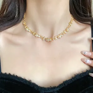 Close-up detail of an elegant gold choker necklace with irregular zircon squares worn by a model