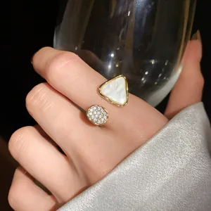 Detailansicht eines offenen Goldrings mit Perlmutt-Dreieck und glitzernden Zirkoniasteinen.