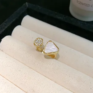 Nahaufnahme eines goldenen Rings mit einem Dreieck aus Perlmutt und Zirkonia-Pavé-Details
