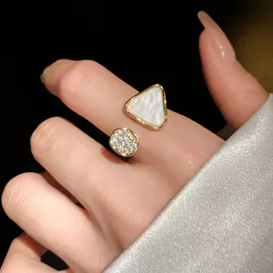 Detailansicht eines eleganten goldenen offenen Dreieckrings mit Perlmutt und Zirkonia