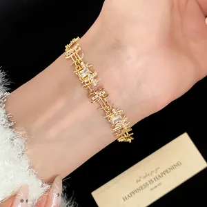 Detail shot of a gold-plated bracelet with irregular square links and sparkling zircon stones