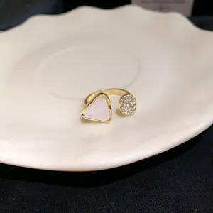 Detailansicht eines goldenen offenen Rings mit Dreieck-Perlmutt und Zirkonia-Inlay