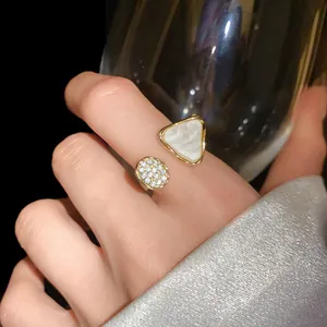 Detailansicht eines goldfarbenen Rings mit Perlmutt-Dreieck und weißem Zirkonia-Besatz
