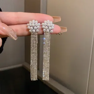 Close-up of elegant French retro pearl earrings with long rhinestone tassels