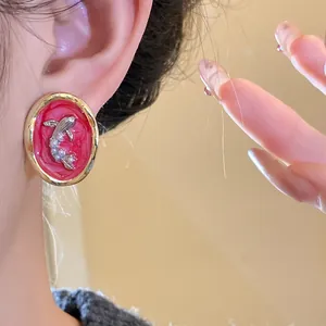 Detailed close-up view of vintage oval goldfish stud earrings featuring pearls worn on ear