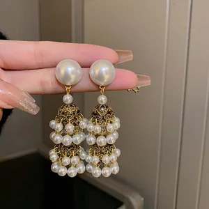 Close-up of elegant French retro pearl tassel earrings with gold filigree details