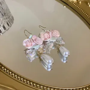 Elegant pink ceramic rose hook earrings featuring teardrop pearls and faceted clear crystals
