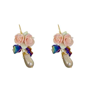 Elegant ceramic rose earrings with blue iridescent bows and teardrop pearls