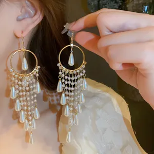 Detail view of French vintage pearl tassel earrings with gold finish and silver needles.