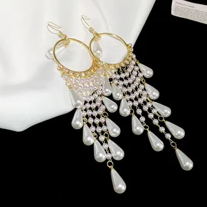 Macro detail of French vintage gold hoop earrings with elegant pearl tassels