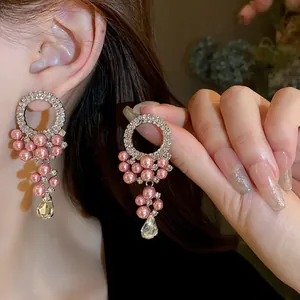 Close-up of French vintage pink pearl tassel earrings with rhinestones on model