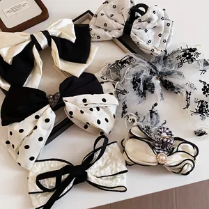 Detail view of various elegant black and white fabric bow hair clips and claws