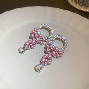 Close-up view of French vintage silver needle earrings with pink pearls and crystals