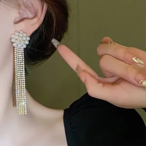Close-up of elegant long tassel earrings with pearls and shimmering rhinestones