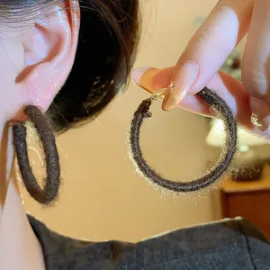 Detailed close-up of fuzzy cloth-wrapped hoop earrings showing warm winter texture
