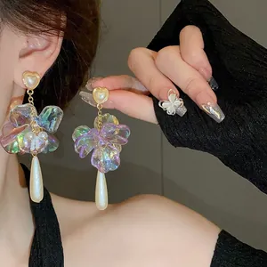Close-up detail of French vintage earrings with iridescent flowers and long pearl tassels.