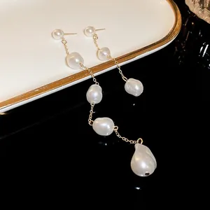 Close-up detail of French vintage gold chain earrings with elegant baroque pearls