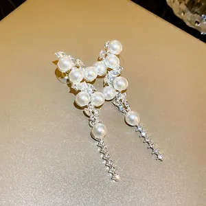 Detailed view of French vintage pearl tassel earrings with crystals on golden surface