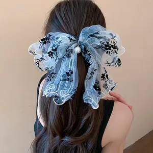 Detail of elegant lace butterfly bow hair clip with floral embroidery and pearl