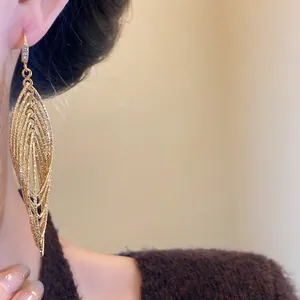 Close-up detail of vintage gold layered hollow oval drop earrings with zircons