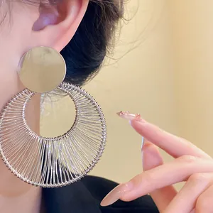 Detailansicht eleganter silberner runder Ohrringe mit Hohlmuster an einem Model