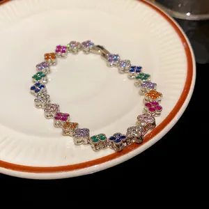 Elegant clover link bracelet featuring vibrant micro-pave cubic zirconia on a white plate
