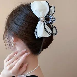 Elegant fabric bow hair claw clip with pearl detail and gingham accent for hair styling