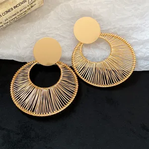 Detailansicht goldener runder Ohrhänger mit filigranem Drahtgeflecht-Design