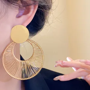 Detailansicht eleganter goldener, hohler, runder Ohrhänger mit Drahtwicklung