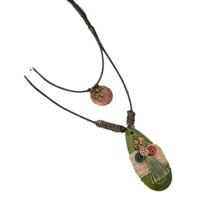 Bohemian teardrop necklace with green tassel and decorative buttons on hemp rope