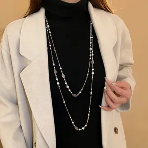 Detail shot of vintage double-layer pearl necklace with flower charms on a coat