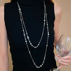 Elegant vintage long pearl necklace with flower accents, ideal for sweaters.